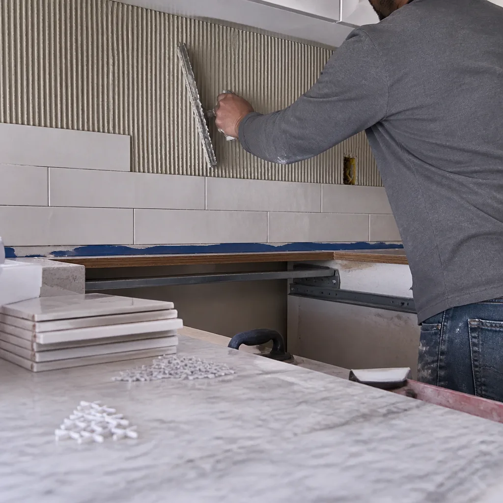 Professional contractor applying thin-set mortar during a kitchen remodeling project